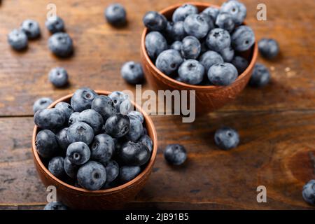 Freshly picked blueberries in a clay bowl. Healthy berry, organic food, antioxidant, vitamin, blue food. Stock Photo