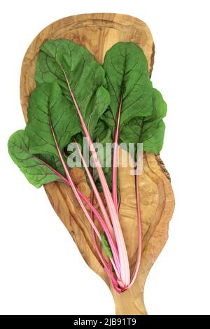 Swiss chard ruby red vegetable leaves on olive wood board. Very high in vitamin A, C B and K, potassium, magnesium and dietary fibre. On white. Stock Photo