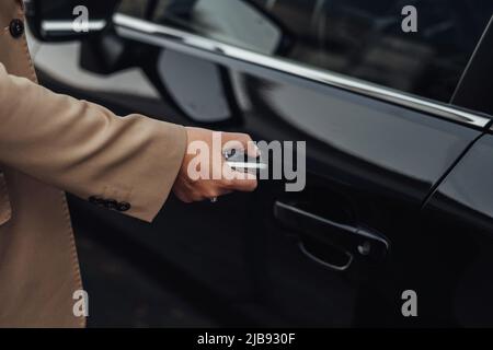 Woman Hand Pressing the Button on the Remote Car Key to Open or Close Door Stock Photo