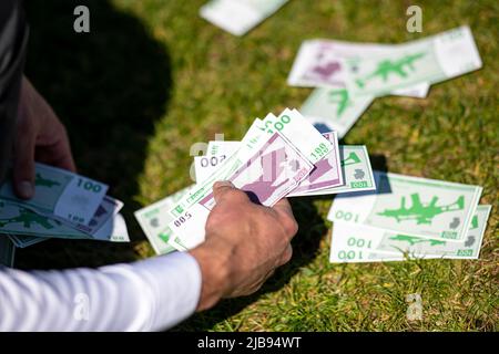 Berlin, Germany. 03rd June, 2022. An activist from an alliance of various civil society organizations lifts fake bills at a rally in front of the Bundestag against the 100-billion-euro special fund. Credit: Fabian Sommer/dpa/Alamy Live News Stock Photo