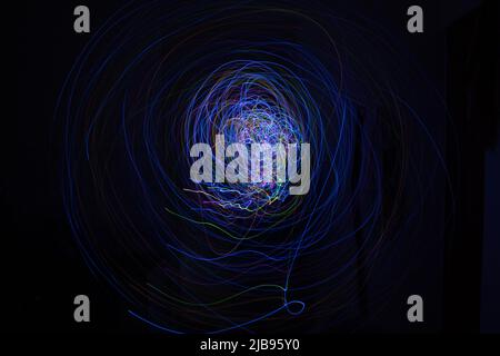 Light painting Abstract colorful irregular lines or patterns on black background with long exposure for wallpaper Stock Photo