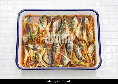 small fish escabeche ( deep fried horse mackerel marinated in spicy vinegar sauce ) Stock Photo