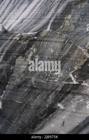 Surface of a cut of gray Karelian marble rock in Ruskeala in Karelia, for use as an abstract background and texture. Stock Photo