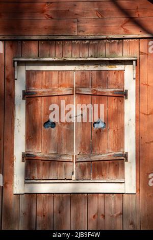 Red ocher wooden window shutters at Seurasaari Open-Air Museum in Helsinki, Finland Stock Photo