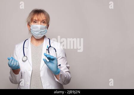 Doctor, nurse or scientist in blue gloves holding syringe and ampoule. Vaccination, medicine and treatment concept. Stock Photo