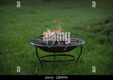 A fire ring, or fire pit, burns safely in a homeowners backyard. Stock Photo