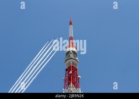 The Japan Air Self-Defense Force (JASDF) Blue Impulse aerobatics team flies past Tokyo Tower in Tokyo. From 12:40 to 1 pm the Kawasaki T4 aircraft of the Japanese Air Self Defence Force aerobatics display team circled the major sites of the city along with hospitals caring for Corona patients, trailing white smoke, as a 'thank you' to healthcare workers for their efforts during the two-month-long state of emergency declared by the Japanese government in response to the COVID-19 pandemic which ended on June 1st Despite Japan appearing to have avoided the high infection and mortality rates of so Stock Photo