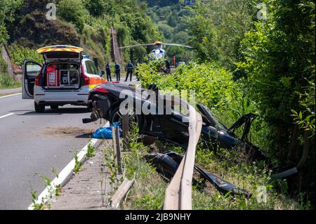 Polich, Germany. 04th June, 2022. 04 June 2022, Rhineland-Palatinate, Pölich: A sports car is trapped after an accident under a guardrail on the B53 federal highway between Mehring and Pölich. One person was slightly injured in the accident, a 53-year-old from Trier died. The driver of the accident is on the run, according to the Trier police department. The police are looking for witnesses. Photo: Harald Tittel/dpa Credit: dpa picture alliance/Alamy Live News Stock Photo