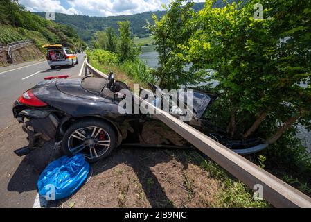 Polich, Germany. 04th June, 2022. 04 June 2022, Rhineland-Palatinate, Pölich: A sports car is trapped after an accident under a guardrail on the B53 federal highway between Mehring and Pölich. One person was slightly injured in the accident, a 53-year-old from Trier died. The driver of the accident is on the run, according to the Trier police department. The police are looking for witnesses. Photo: Harald Tittel/dpa Credit: dpa picture alliance/Alamy Live News Stock Photo