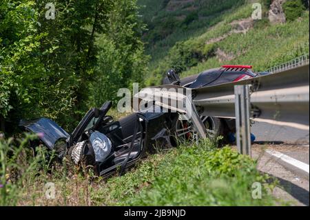 Polich, Germany. 04th June, 2022. 04 June 2022, Rhineland-Palatinate, Pölich: A sports car is trapped after an accident under a guardrail on the B53 federal highway between Mehring and Pölich. One person was slightly injured in the accident, a 53-year-old from Trier died. The driver of the accident is on the run, according to the Trier police department. The police are looking for witnesses. Photo: Harald Tittel/dpa Credit: dpa picture alliance/Alamy Live News Stock Photo