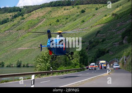 Polich, Germany. 04th June, 2022. 04 June 2022, Rhineland-Palatinate, Pölich: A police helicopter lands at the scene of an accident where a sports car was trapped under a crash barrier on the B53 federal highway. One person was slightly injured in the accident, and a 53-year-old man from Trier died. The driver of the accident is a fugitive, according to the Trier police inspection. The police are looking for witnesses. Photo: Harald Tittel/dpa Credit: dpa picture alliance/Alamy Live News Stock Photo