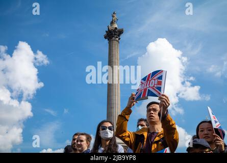 A spectator holds up a Union Flag under Nelson's Column in Trafalgar Square in London as he waits for Platinum Jubilee celebrations to begin 2 June 20 Stock Photo
