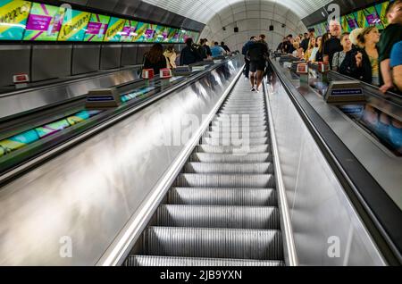 Passengers ride escalators at Liverpool Street station on London's newest undergound line, the Elizabeth Line, which partially opened in May 2022 afte Stock Photo