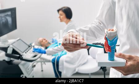 Enlarged thyroid gland, ultrasound diagnosis in endocrinology. Exam endocrine system of woman patient at medical clinic with ultrasound machine Stock Photo