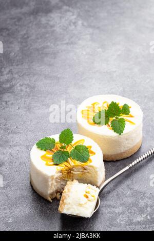 Mini  Cheesecakes decorated with yellow jam on gray background Stock Photo
