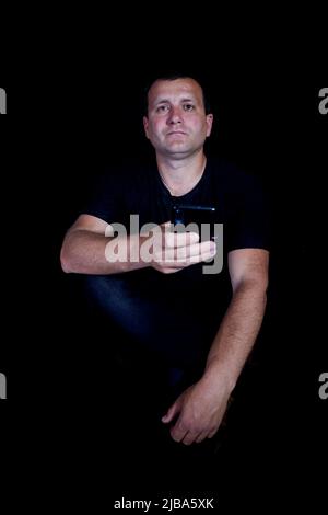 Man with phone on a black background. Stock Photo
