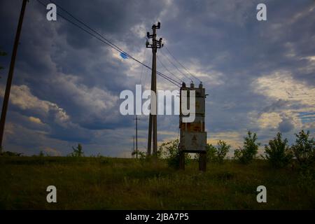Electro transformer on a background of cloudy sky with dark clouds. Stock Photo