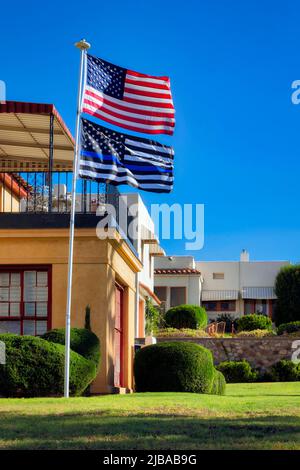 The morning sun warms the American and Thin Blue Line flags flying proudly in the Manhattan Heights Historic District of El Paso, Texas. Stock Photo