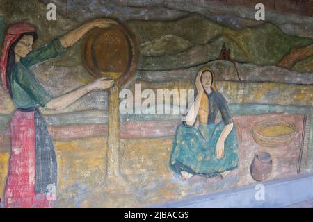 Wall painting with two Armenian women in national costumes, with a church and mountains in the background Stock Photo