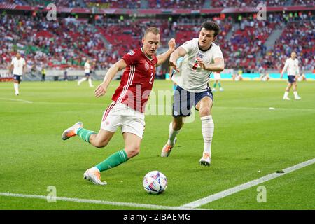 Hungary's Adam Lang (left) and England's Harry Maguire battle for the ball during the UEFA Nations League match at the Puskas Arena, Budapest. Picture date: Saturday June 4, 2022. Stock Photo