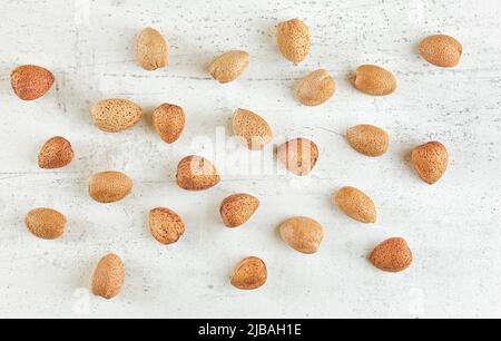 Top down view, whole almonds in shell on white stone board Stock Photo