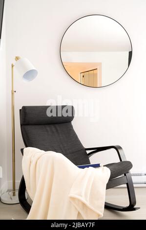 An easy chair with a blanket and book in a report Air BnB hotel unit. Stock Photo