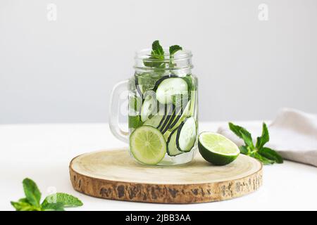 Infused water with cucumber, lime and mint in a glass jar Stock Photo