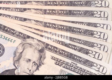 A group of used twenty dollar United States of America banknotes displayed in a fan like pattern stack on a table. Stock Photo