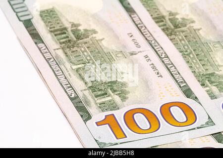 Closeup shallow depth of field shot of the large 100 text design on the back side of United States of America one hundred dollar bill banknote. Stock Photo