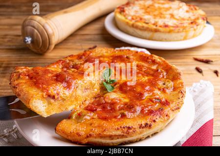 Chicago Style Deep Dish Cheese Pizza with Tomato Sauce, on wooden background Stock Photo