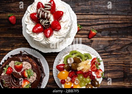Various cakes on wooden background or table. Assortment of cakes for celebrations. Stock Photo