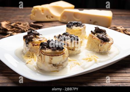 Homemade rondelli with four cheese and mushuroom sauce in white plate on rustic white wooden table background, soft light Stock Photo