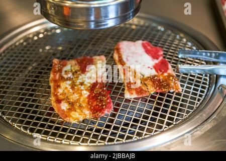 Grilled fat beef slices on Korean charcoal grill Stock Photo