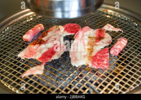 Grilled fat beef slices on Korean charcoal grill Stock Photo