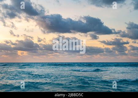 Open seascape under cloudy sky. sunset in the evening light over the sea waves. Stock Photo