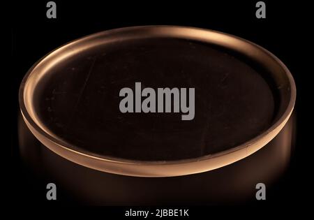 Podium black round tray illuminated in yellow with highlighted circle and reflect on black background for product presentation. Stock Photo