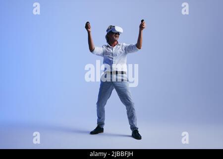 Celebrating success in virtual reality. Cheerful businessman celebrating his victory while wearing a virtual reality headset. Mature businessman worki Stock Photo