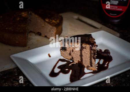 A slice of homemade cinnamon cake with melted chocolate on top. India Stock Photo