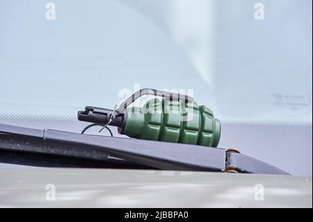 There is an airsoft fragmentation grenade on the windshield wiper of the car Stock Photo