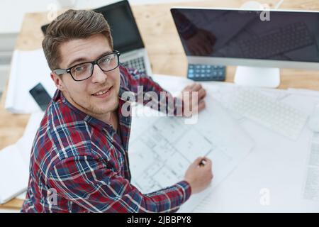 Architect working on drawing table in office Stock Photo