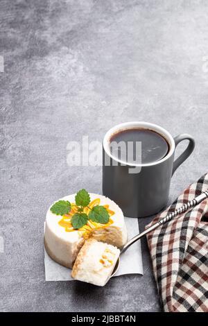 Mini  Cheesecakes decorated with yellow jam on gray background Stock Photo