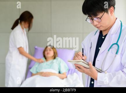 Portrait asian doctor with his colleague and patient in the background Stock Photo