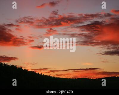Orange and pink sunset with cloudy sky at Mountain Tara in Serbia Stock Photo