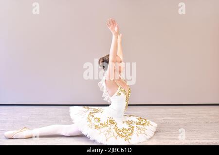 attractive young ballerina acting out. beautiful ballerina sitting forward split Stock Photo