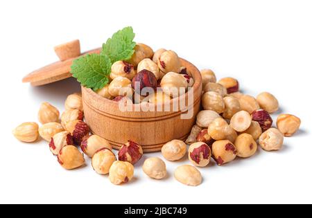 Peeled hazelnuts in a wooden bowl are isolated on a white background. Stock Photo