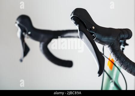 Highway bicycle handlebar in black winding and with brake gearshift knobs on a gray background. Stock Photo