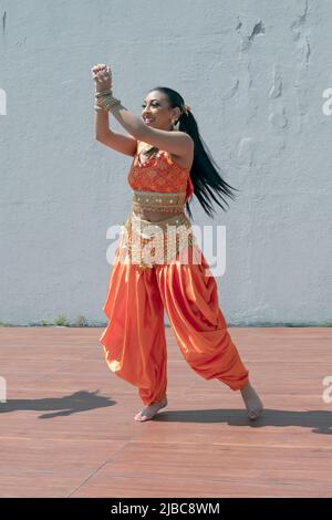 An attractive teenage dancer from the Avantikas group performs at tte Bollywood & Indian Folk Fusion Dance Concert in Charles Drew Park in Queens, NYC Stock Photo