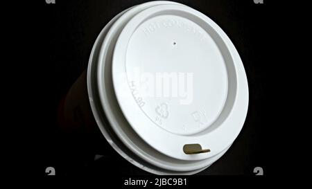 Disposable paper cup with white plastic lid, embossed "HOT CONTENS". Stock Photo
