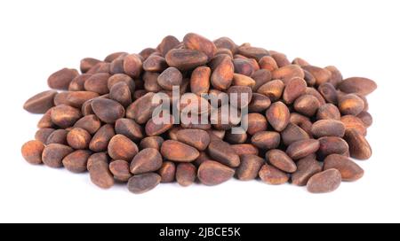 Pine nuts isolated on white background. Pine cones and heap of roasted pine nuts in shells. Stock Photo