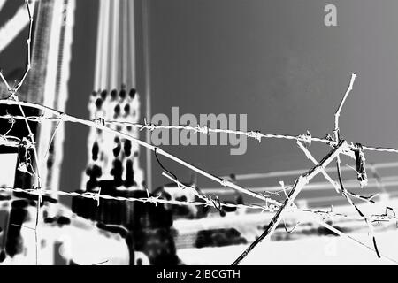 Razor sharp barbed wire fence protecting the industrial area in black and white high contrast. Stock Photo